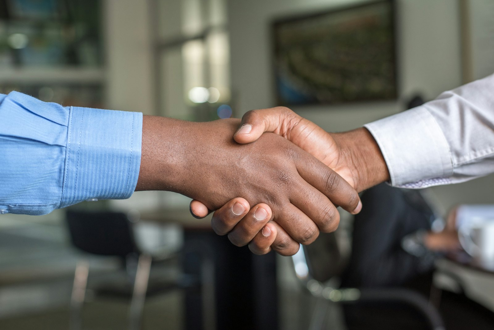 Two executives shaking hands to close an automotive M&A introduction